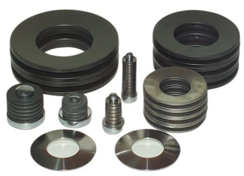 A group of several different kinds of disc springs, including belleville spring washers, made by a custom spring manufacturer in the United States.